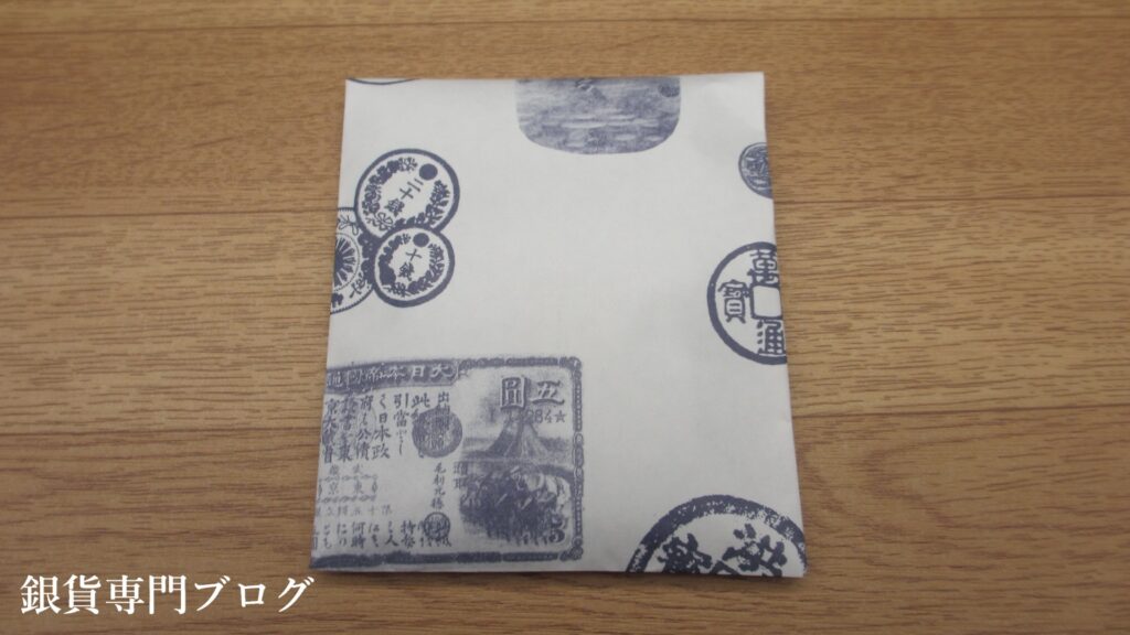 ビニール袋に古銭柄の紙袋